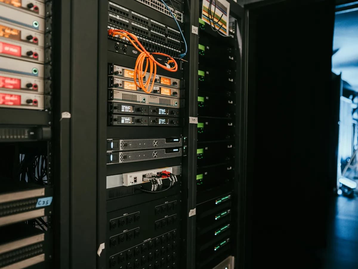 Serverový rack s oranžovou kabeláží a svítícími síťovými prvky