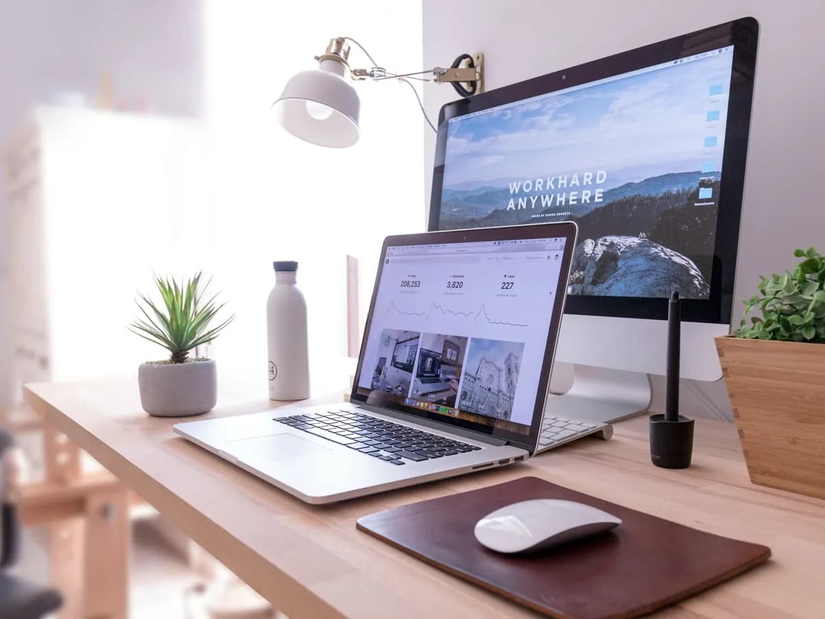 Pracovní stůl s iMacem a MacBookem, na obou obrazovkách otevřený web